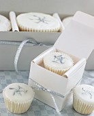 White cup-cakes and petit fours as gifts