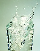 Wasser spritzt aus dem Glas