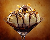 A Dish of Vanilla Ice Cream Topped with Chocolate Sauce and Toasted Almonds