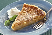 A piece of apple tart with mint and whipped cream