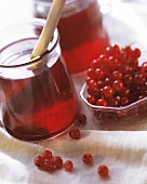 Redcurrant jelly in a jar, redcurrants beside it