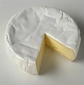 A whole Brie, with a piece cut out