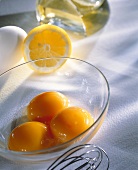 Three egg yolks in a glass dish
