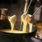Cheese fondue with bread cubes on fondue forks