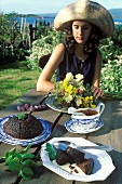 Schottischer Pudding auf Gartentisch, dahinter junge Frau