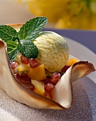 Fruit salad with scoop of ice cream in marzipan wafer bowl