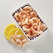 Shrimps in Schälchen und daneben mit Zitronenspalten