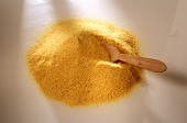 A heap of polenta with wooden spoon