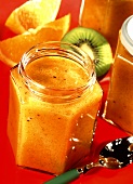 Kiwi and mango jam with spoon in jar