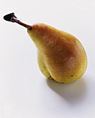 A yellow and red pear with stalk and small leaf