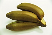 Drei rote Bananen auf Bananenblatt