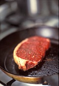 Frying rump steak in a pan