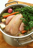 Vegetable stew with whole chicken in pan (before cooking)