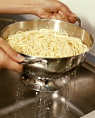 Draining cooked spaghetti 