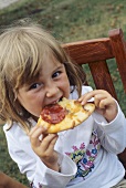 Girl eating pizza in open air