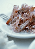 Ein Teller mit leeren Garnelenschalen (Essensüberreste)