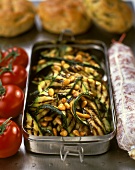 Gegrillte Zucchini mit Pinienkernen, danenben Salami, Tomaten
