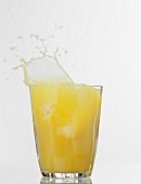 Orange juice spilling out of a glass