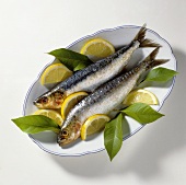 Two sardines with slices of lemon on a platter