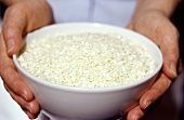 Hände halten Schälchen mit Reis