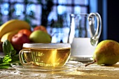 A cup of tea, fruit and a jug of water