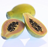 Zwei Papayahälften vor ganzer Papaya