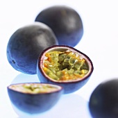 Passion fruits (purple granadilla), whole and halved