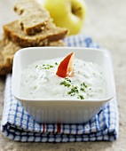 Tzaziki in bowl, wholemeal bowl and apple behind