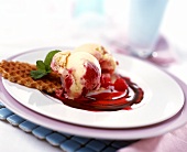 Vanilla and raspberry ice cream with wafers and raspberry sauce