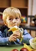 Small boy eating a banana