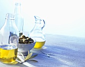 Various olive oils and a bowl of green olives