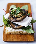 Mushroom & feta sandwich with mustard dressing on wooden board