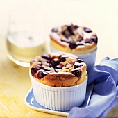 Two blueberry souffles in souffle dishes