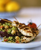 Fried chicken kebabs with couscous and vegetable salad