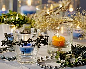 Teelichter mit weihnachtlichen Zweigen als Tischdeko