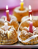Several mini-gugelhupfs with candles on tray