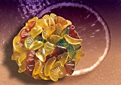 Collage: bowl of wine gums, orange motif as background