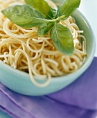 A bowl of cooked spaghetti and basil