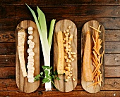 Three sorts of root vegetables on wooden boards, leek, parsley