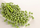 Peas and pea pods on a marble board