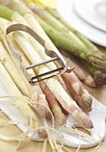 White and green asparagus with peeler