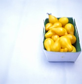 Pear-shaped yellow tomatoes in a cardboard box