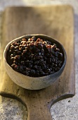 Terracotta bowl of currants on a wooden board