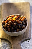Terracotta bowl of raisins on a wooden board