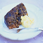 Piece of English Christmas pudding with orange brandy butter