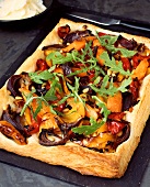 Vegetable pizza with rocket on baking tray