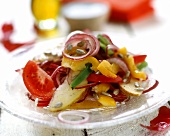Colourful salad with red onions, peppers, apples and tomatoes