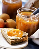 Peach jam on bread and in preserving jar