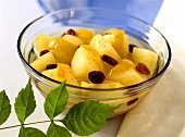 A bowl of apple compote with raisins and lemon rind