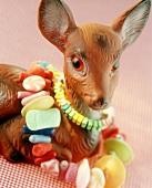 Toy deer and chains of sweets as gift or table decoration